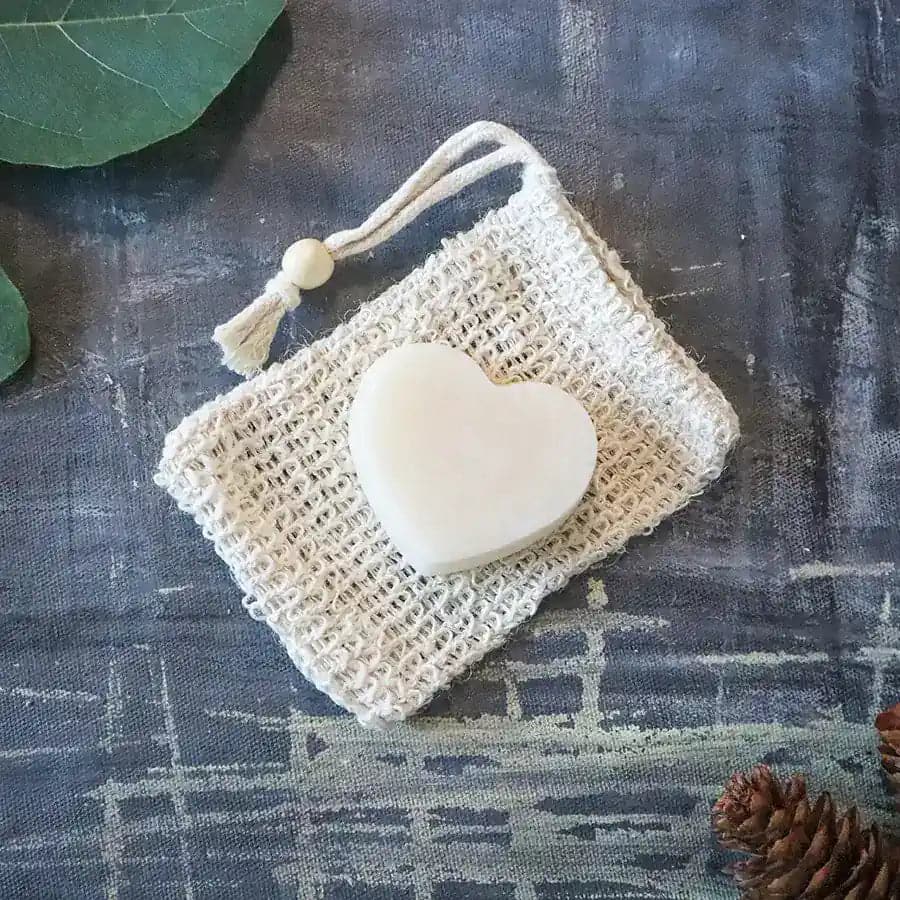 Round zero waste hydrating solid conditioner bar infused with lavender and shea butter on soap dish