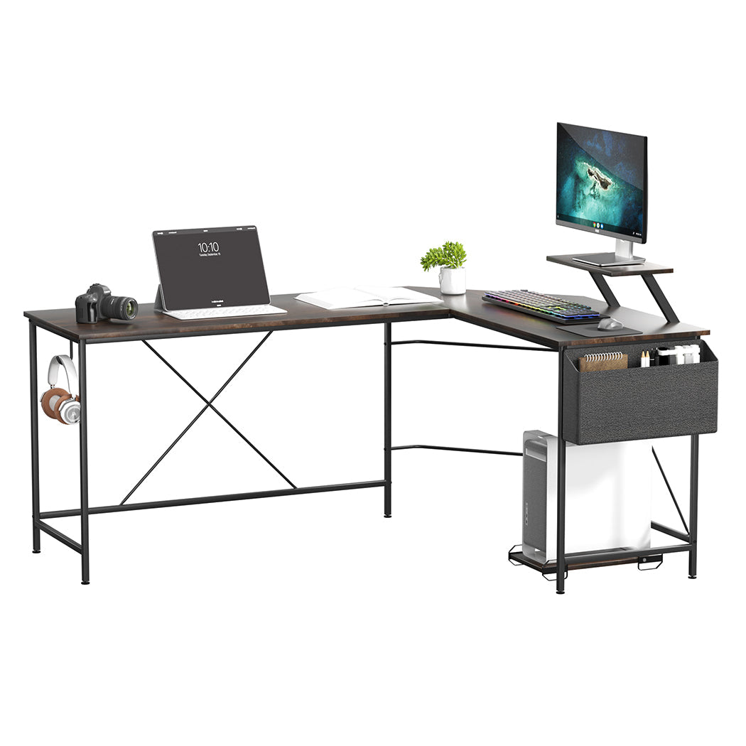 Brown L-shaped wooden computer desk with steel frame, movable monitor stand, and attached storage bag.