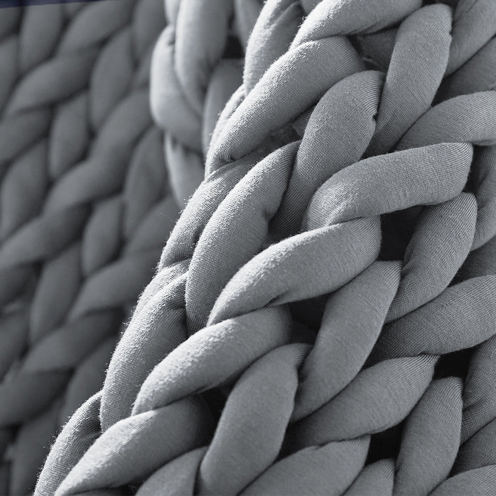 Chunky grey knitted weighted blanket folded neatly on a bed for anxiety relief and restful sleep — view 4