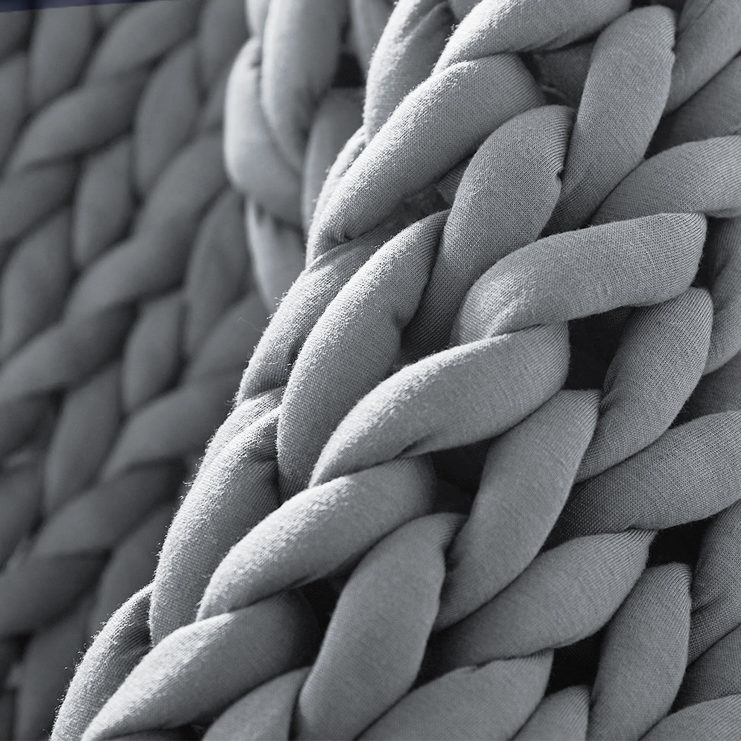 Chunky grey knitted weighted blanket folded neatly on a bed for anxiety relief and restful sleep — view 4