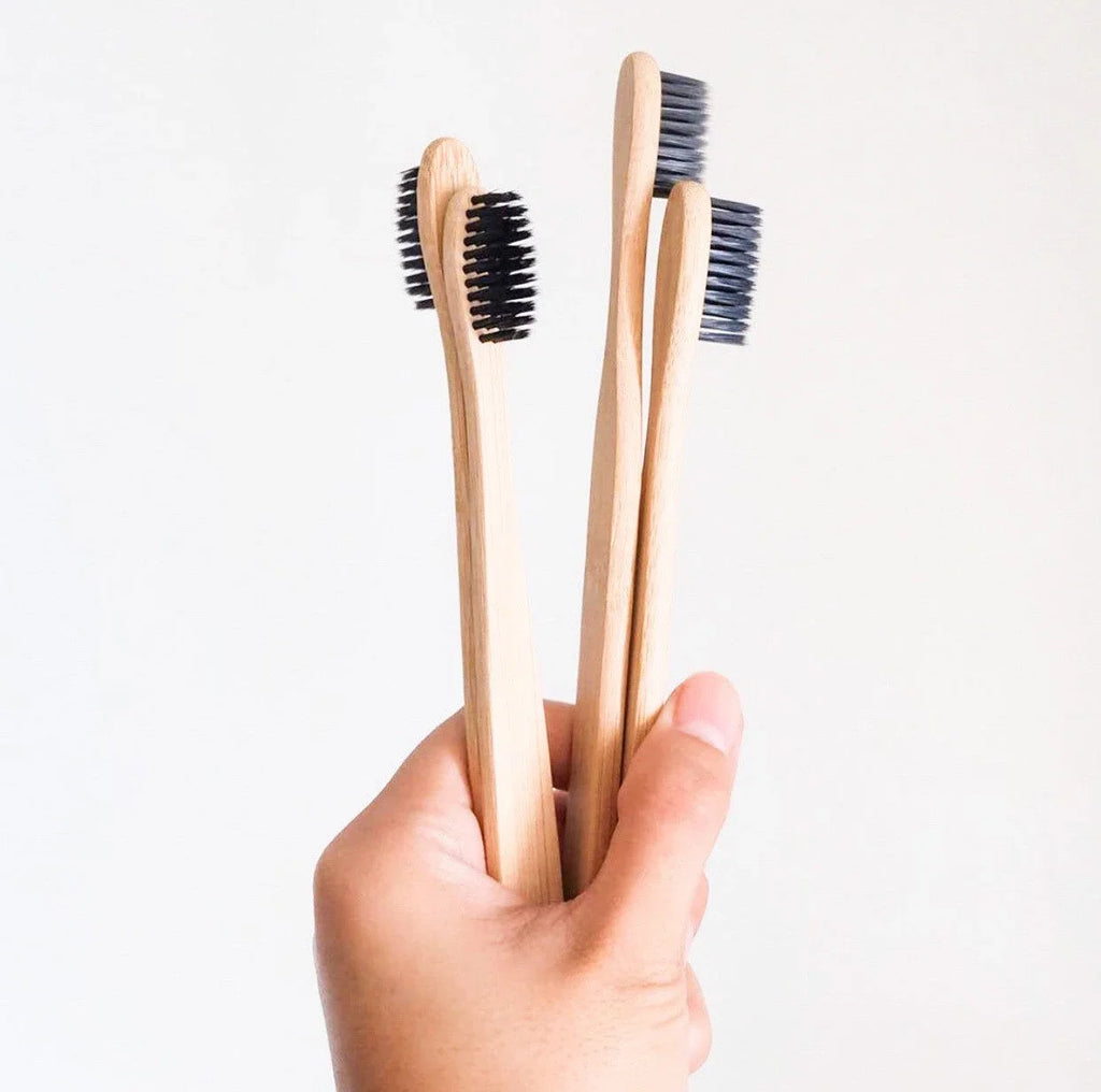 Bamboo charcoal toothbrush with black soft bristles and natural wooden handle on a clean background — view 2