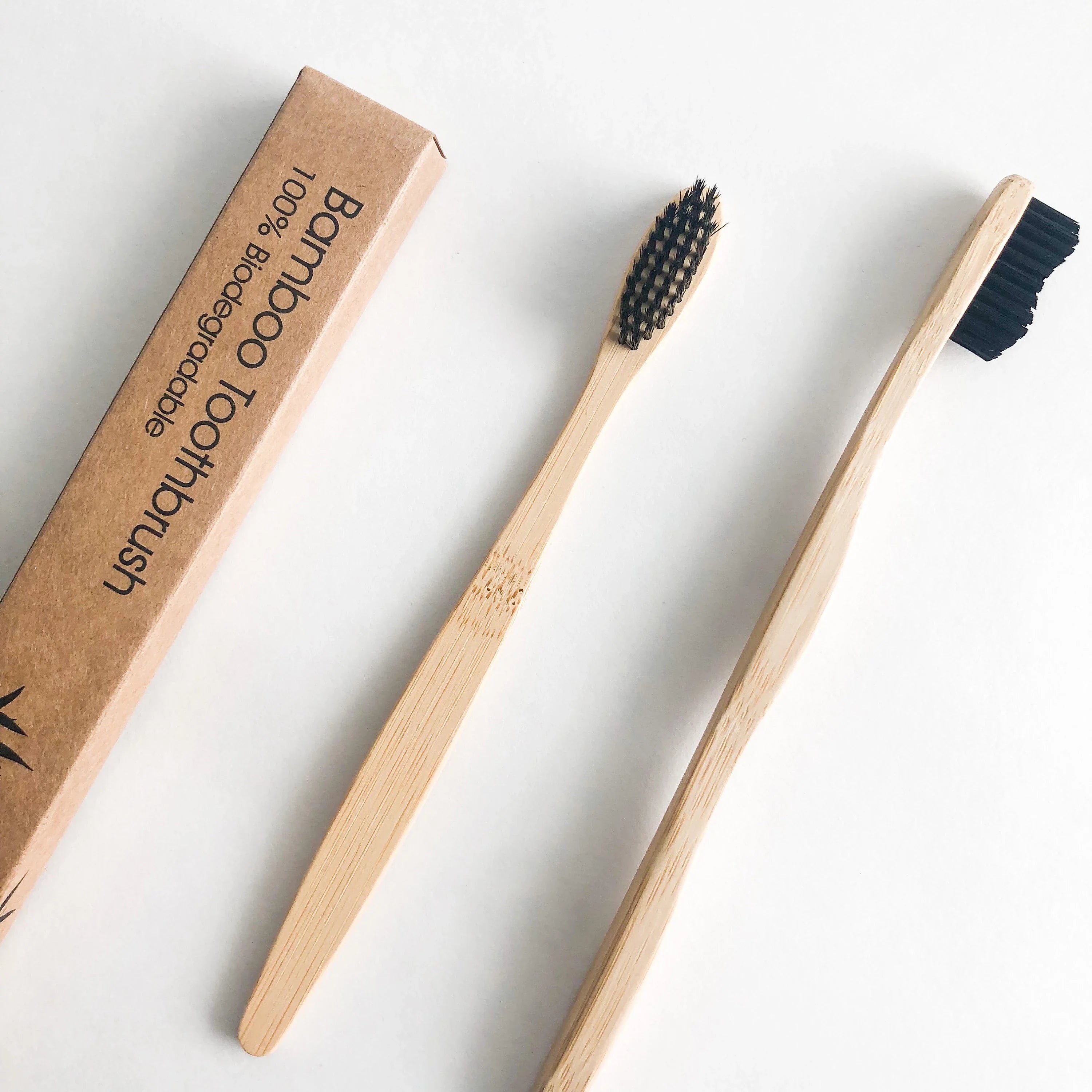 Bamboo charcoal toothbrush with black soft bristles and natural wooden handle on a clean background