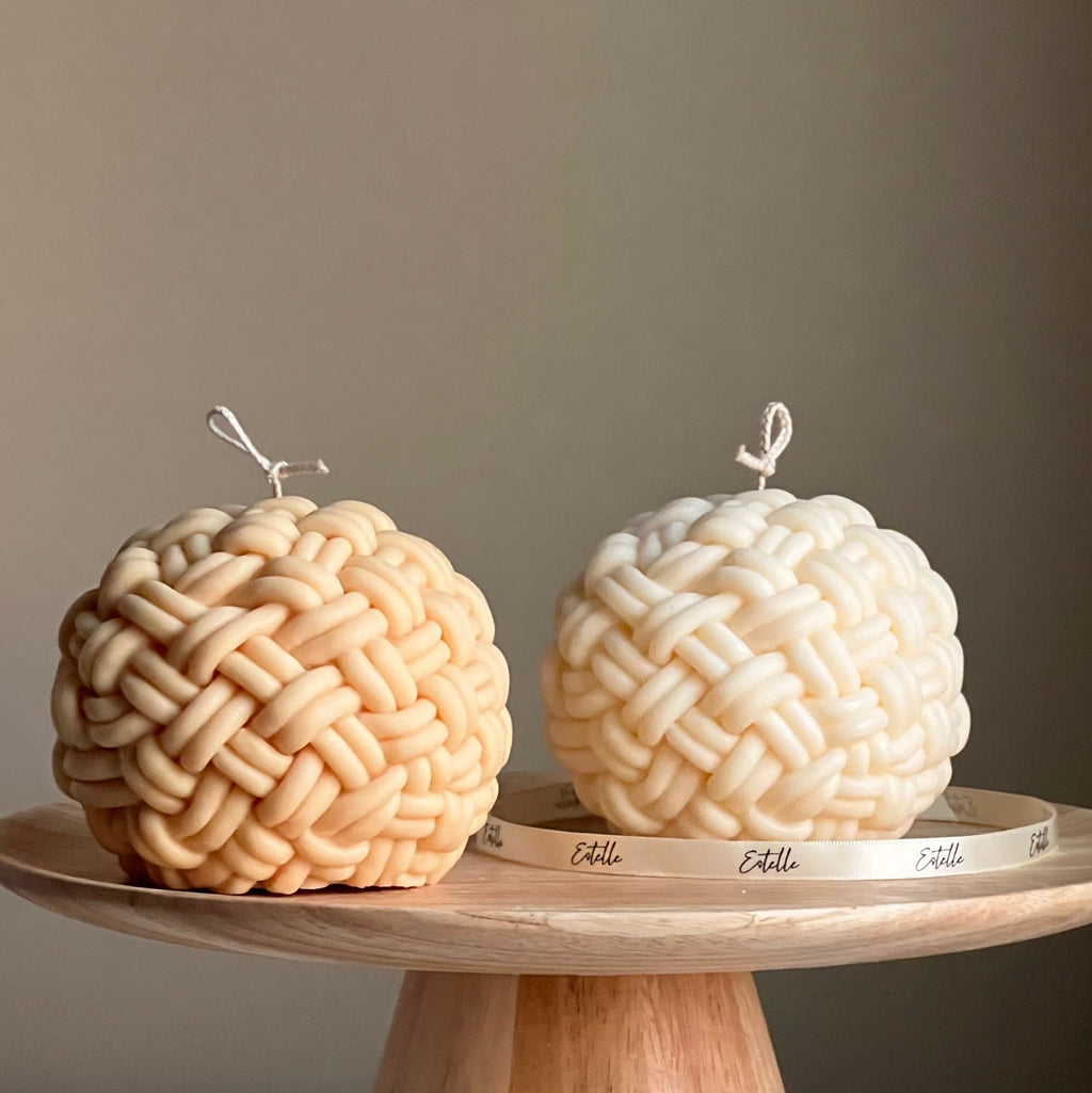 Large handmade yarn ball candle made of vegan soy wax in a cozy home decor setting
