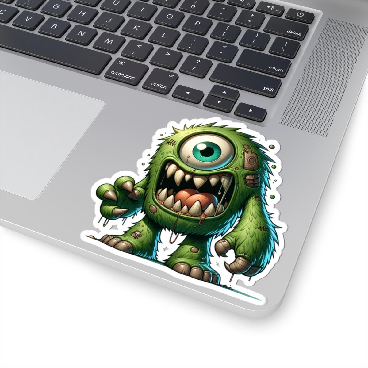 Green cyclops monster vinyl sticker with bold fangs and wild fur for laptop customization — view 5