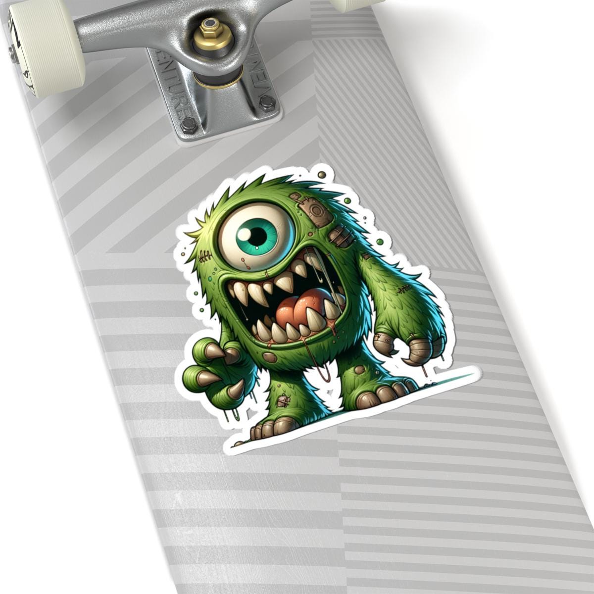Green cyclops monster vinyl sticker with bold fangs and wild fur for laptop customization — view 2