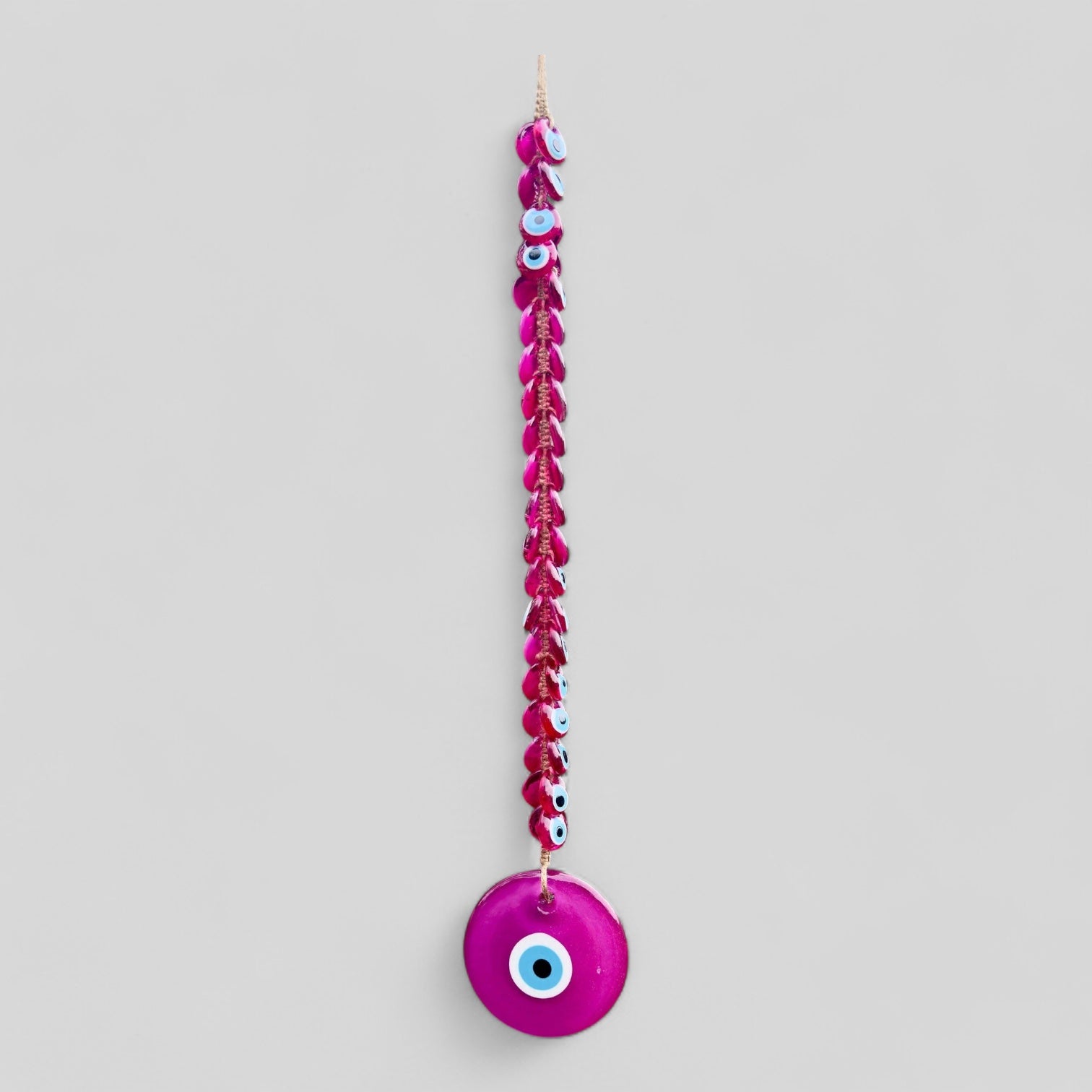 Pink evil eye wall hanging decor with 41 handblown glass beads and intricate macrame detailing.