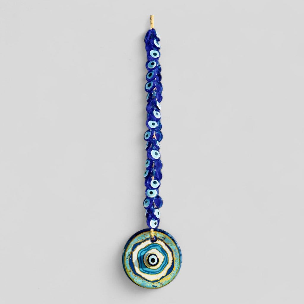 Macrame evil eye wall decor featuring a large handblown blue glass pendant and woven beads