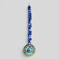 Macrame evil eye wall decor featuring a large handblown blue glass pendant and woven beads