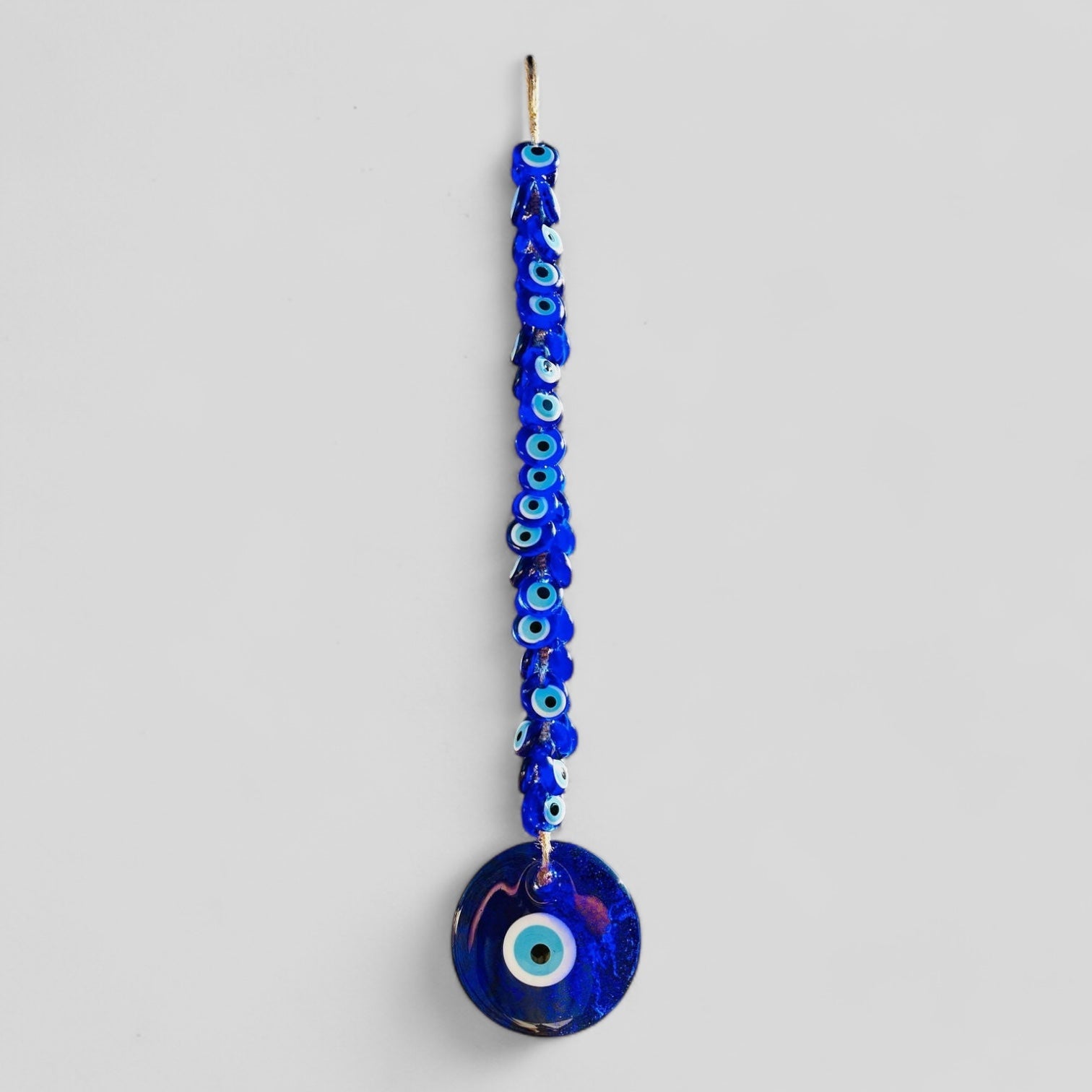 Large blue glass evil eye wall hanging with 40 smaller macrame beads for home protection.