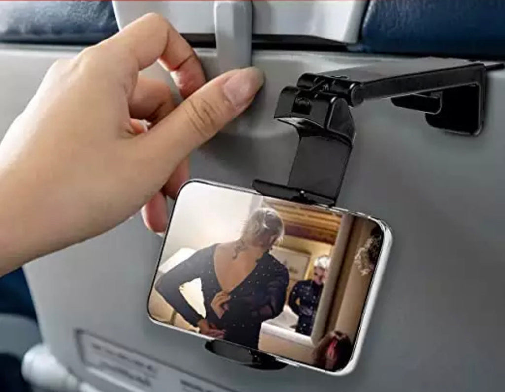Black universal airplane phone stand attached to a seat back tray holding a smartphone