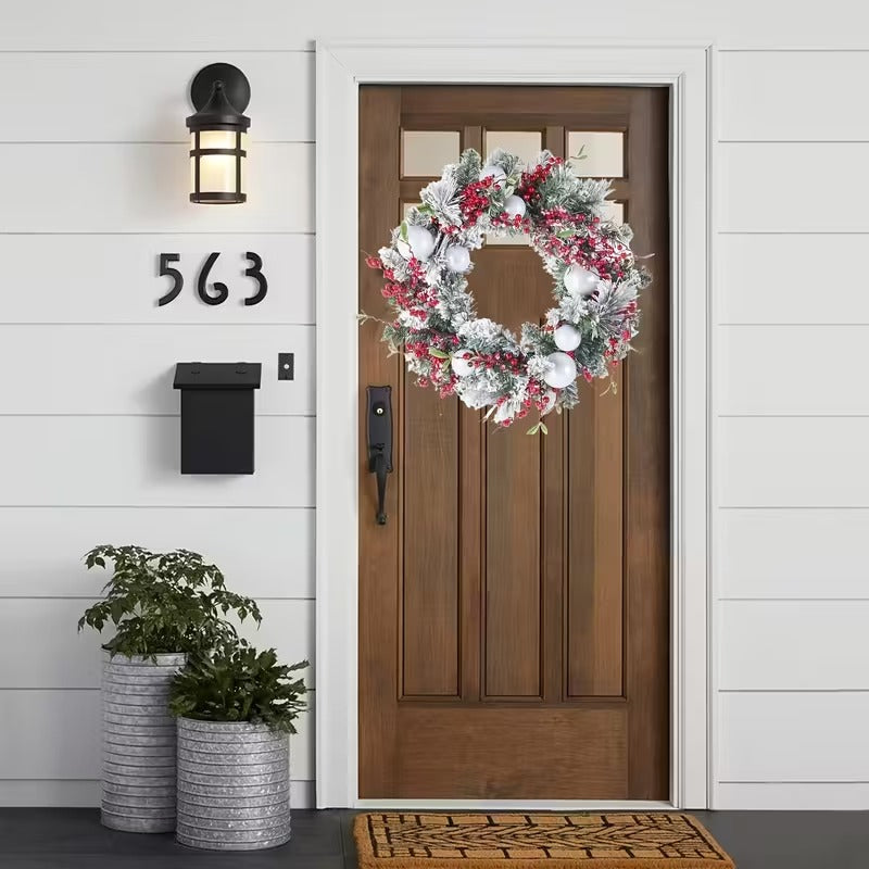 Artificial green Christmas wreath decorated with vibrant red berries and white balls for holiday doors — view 3