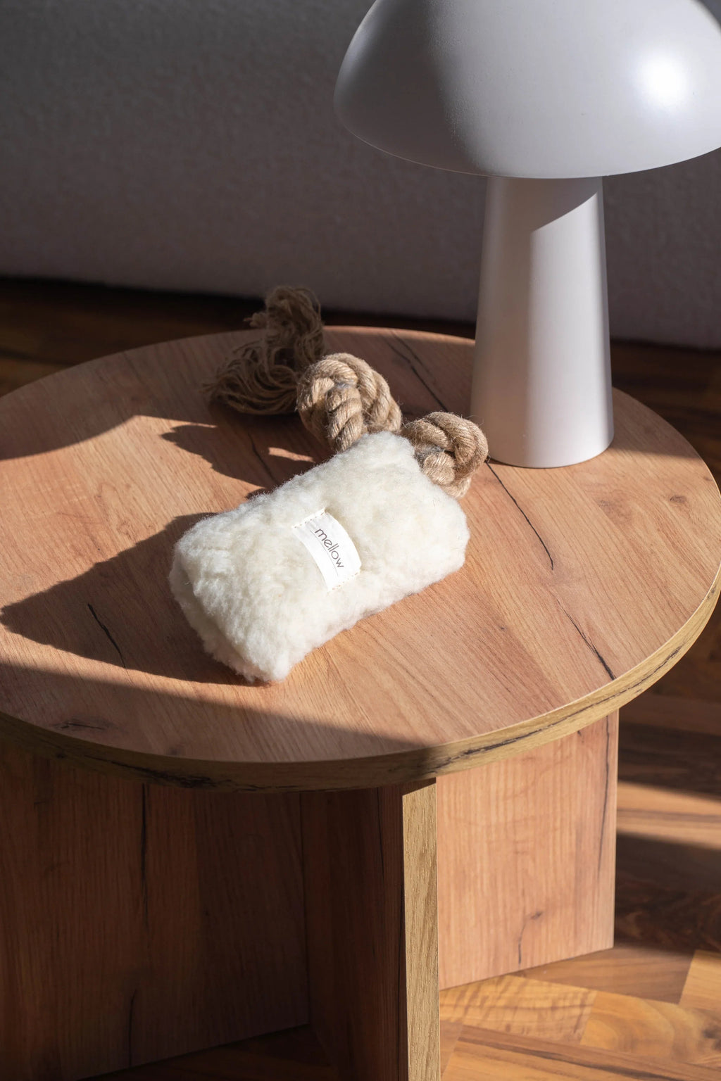 Natural woolen dog tug toy in white with a durable woven jute loop handle
