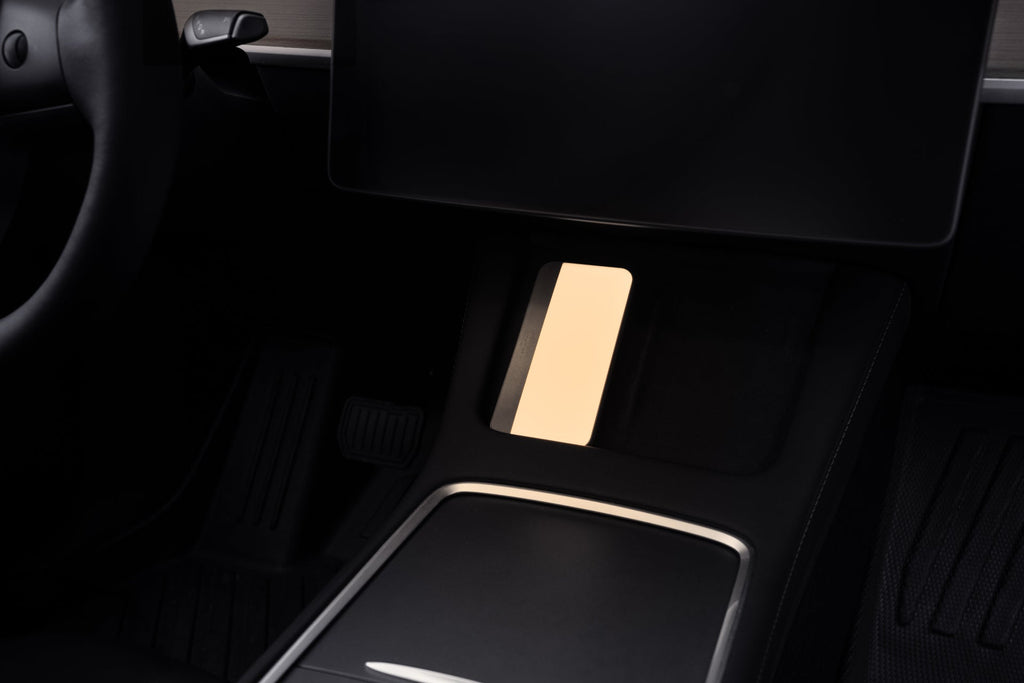 Portable LED light with MagSafe wireless charging illuminating an electric vehicle interior — view 3