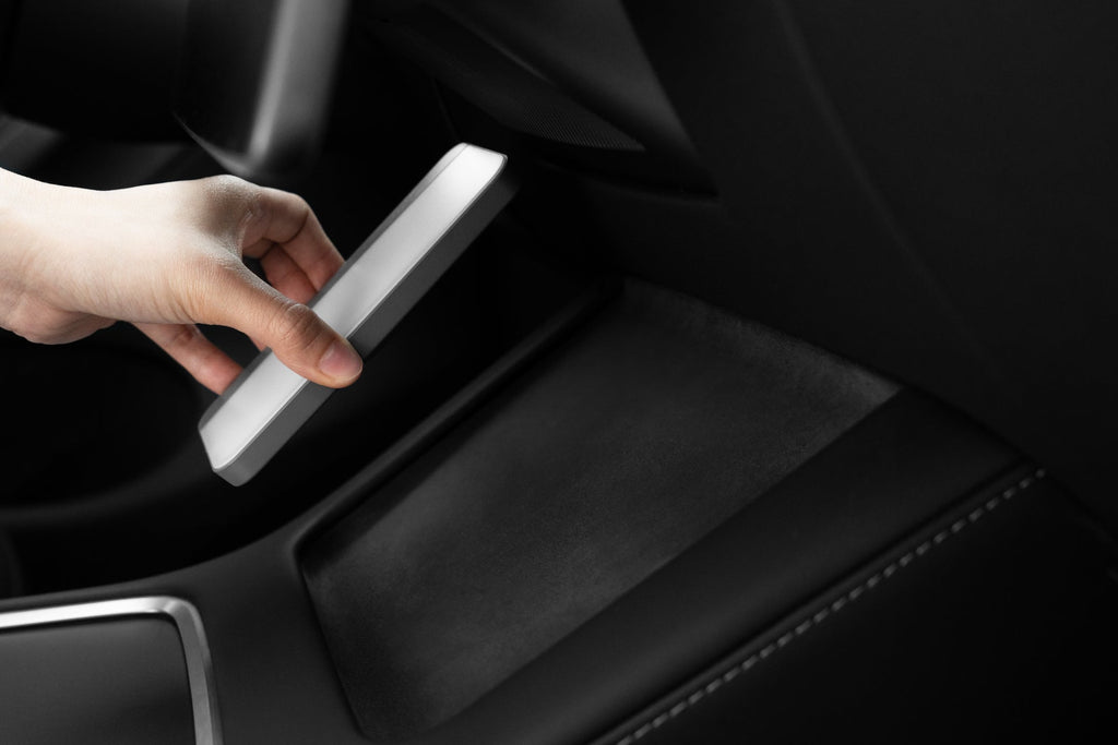 Portable LED light with MagSafe wireless charging illuminating an electric vehicle interior — view 4