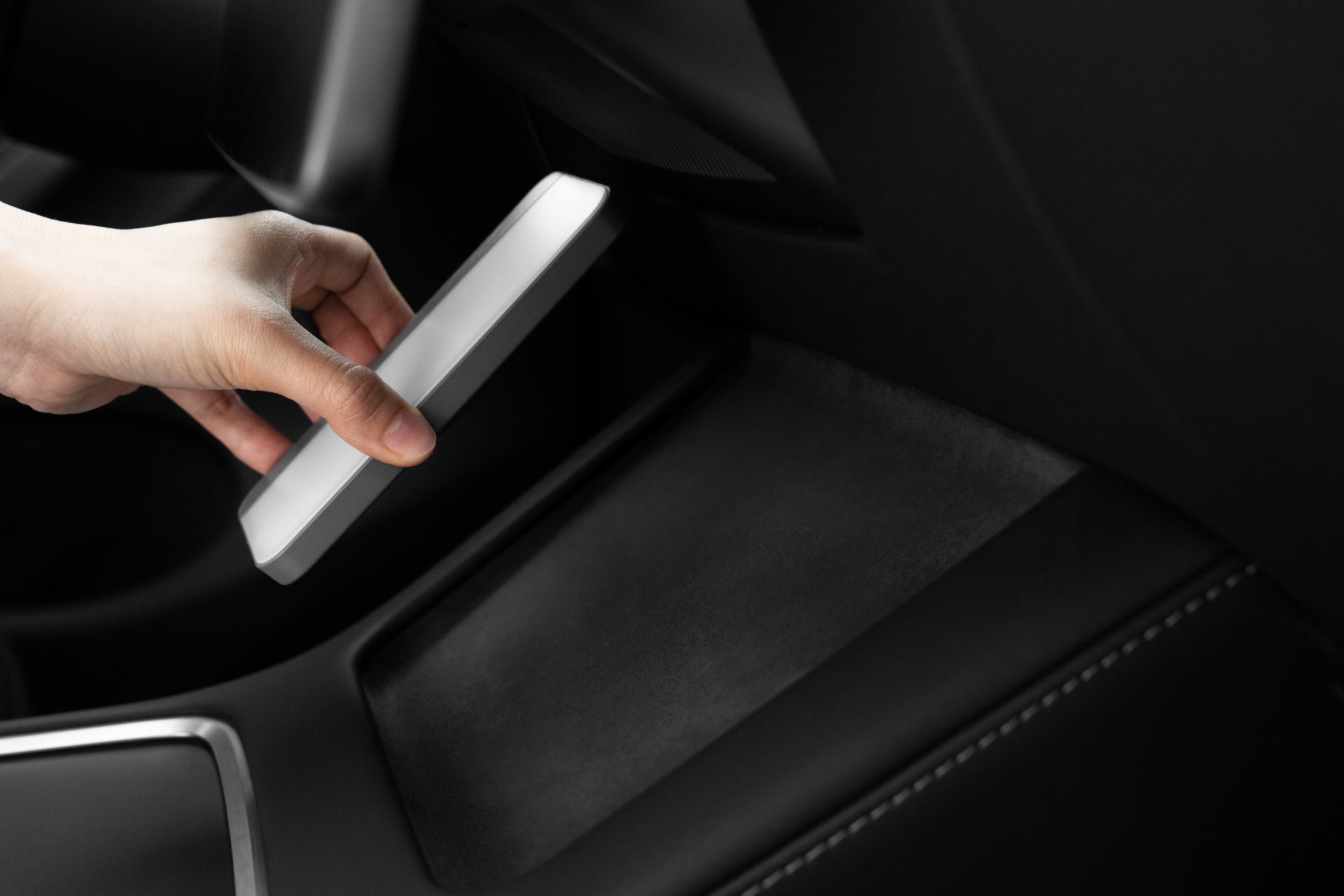 Portable LED light with MagSafe wireless charging illuminating an electric vehicle interior — view 4