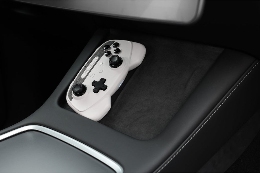 Two wireless game controllers and metallic 4-port USB dashcam hub for Tesla interior — view 4