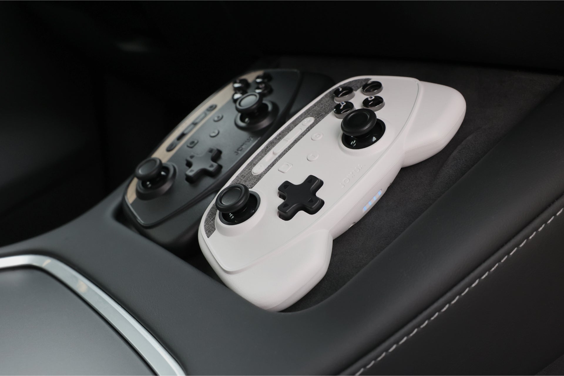 Two wireless game controllers and metallic 4-port USB dashcam hub for Tesla interior — view 3