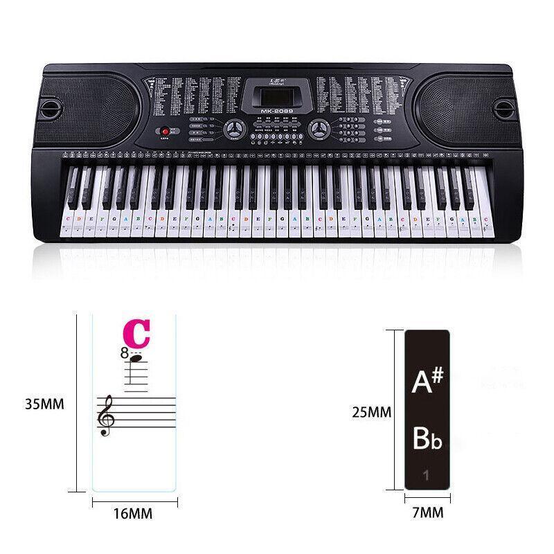 Transparent piano note stickers applied to a full-size keyboard showing staff notation — view 3