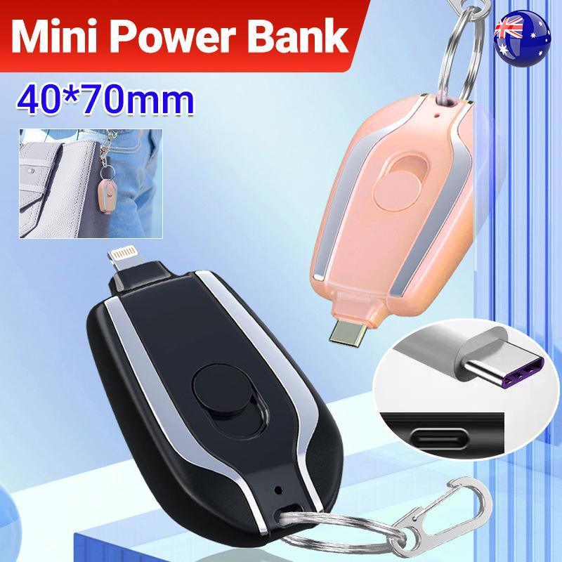 Black and pink mini keychain power bank with carabiner clip attached to a backpack