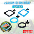 Black floating fish feeding ring with adjustable suction cup attached to glass aquarium