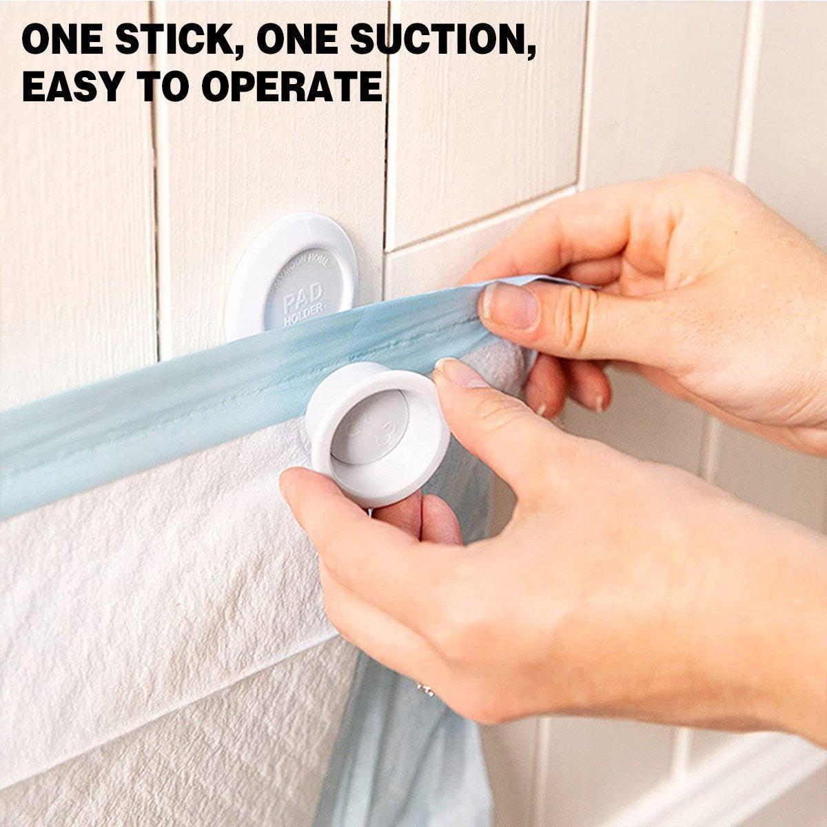 Magnetic wall mounted dog pee pad holder clips in white plastic securing a training pad — view 5