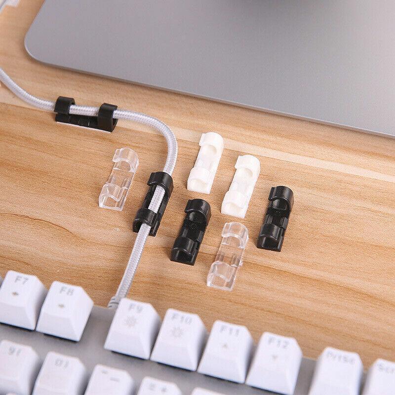 Set of twenty self-adhesive plastic cable management clips organizing power cords on a wooden desk — view 5
