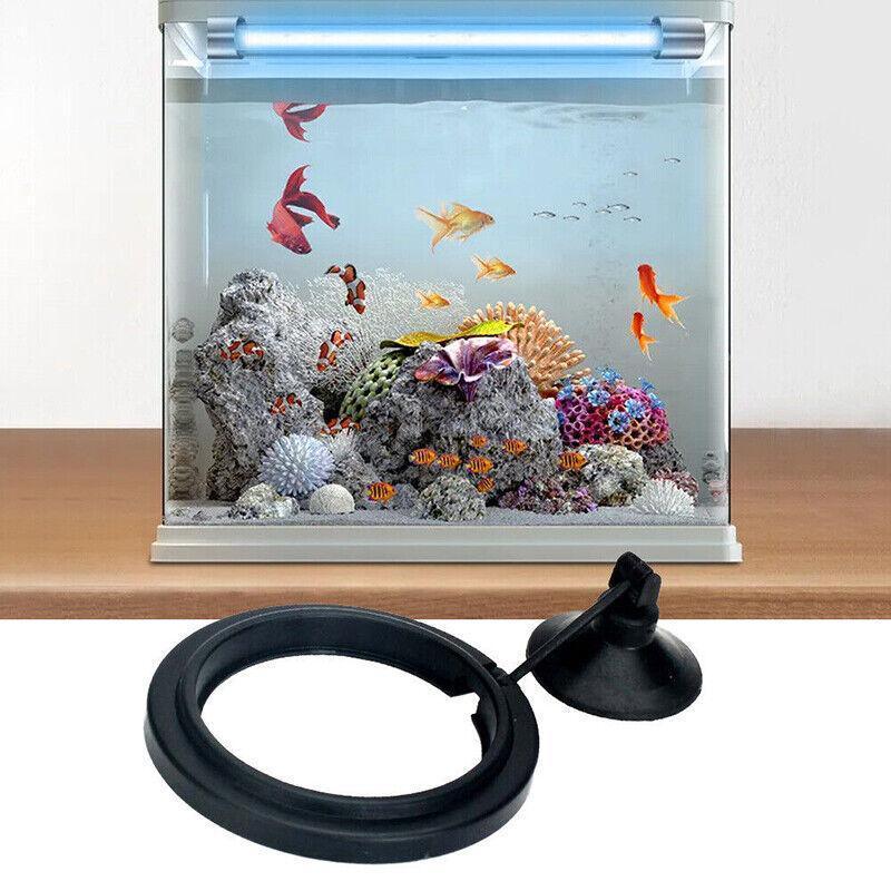 Black floating fish feeding ring with adjustable suction cup attached to glass aquarium — view 4