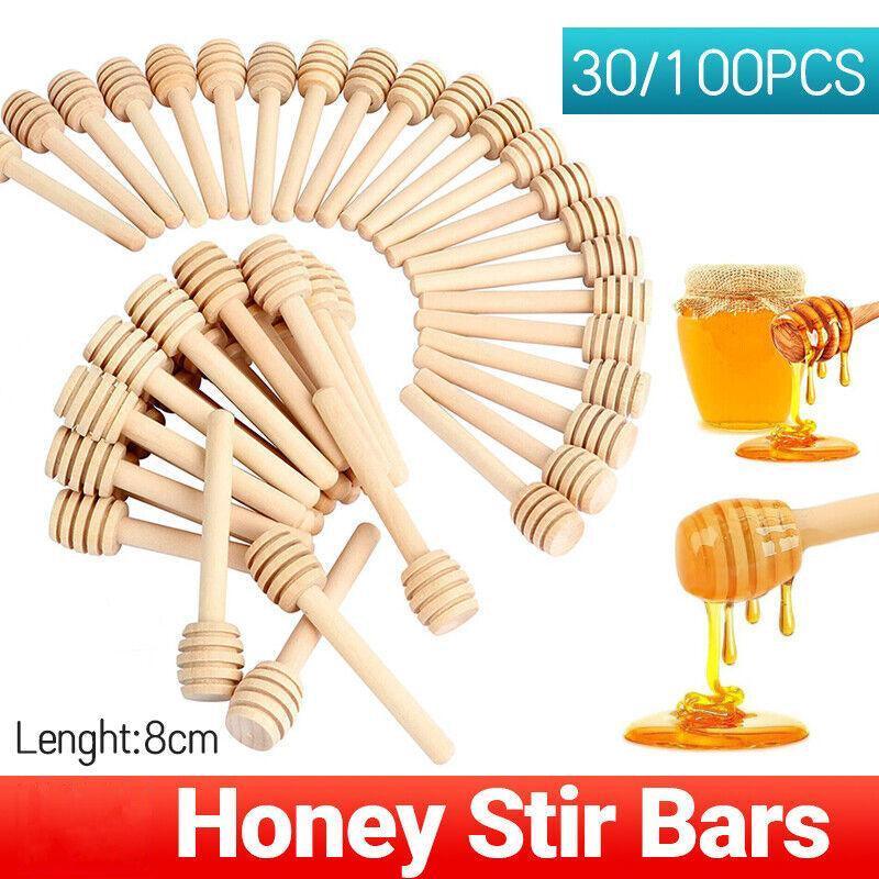 Mini wooden honey dipper sticks with carved grooves arranged together for drizzling syrup and party favors