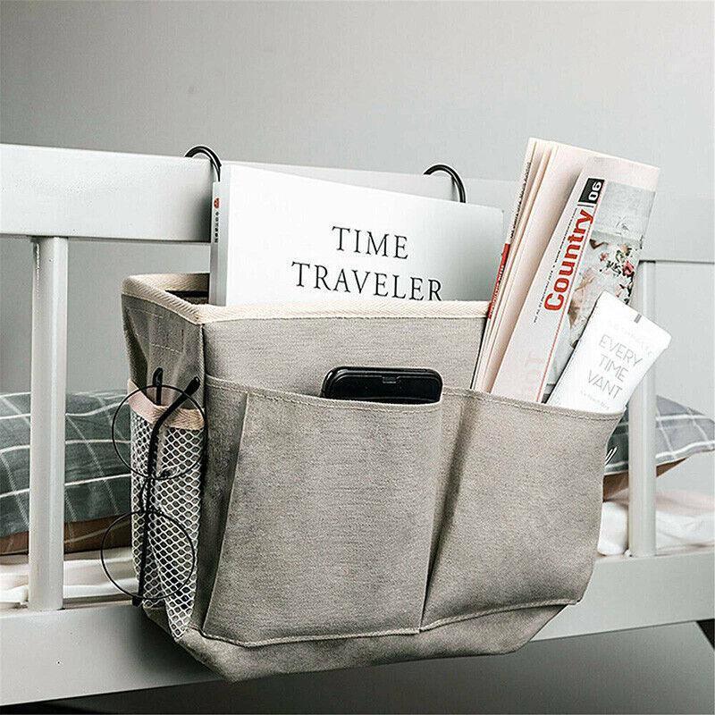 Canvas bedside storage caddy hanging on a bed frame holding books and remote controls — view 5