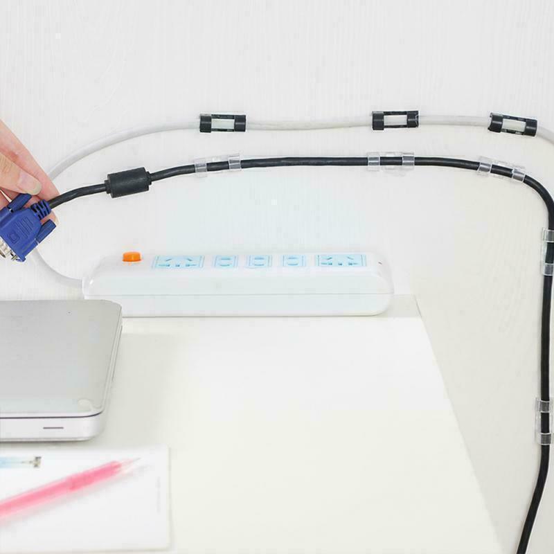 Set of twenty self-adhesive plastic cable management clips organizing power cords on a wooden desk — view 3