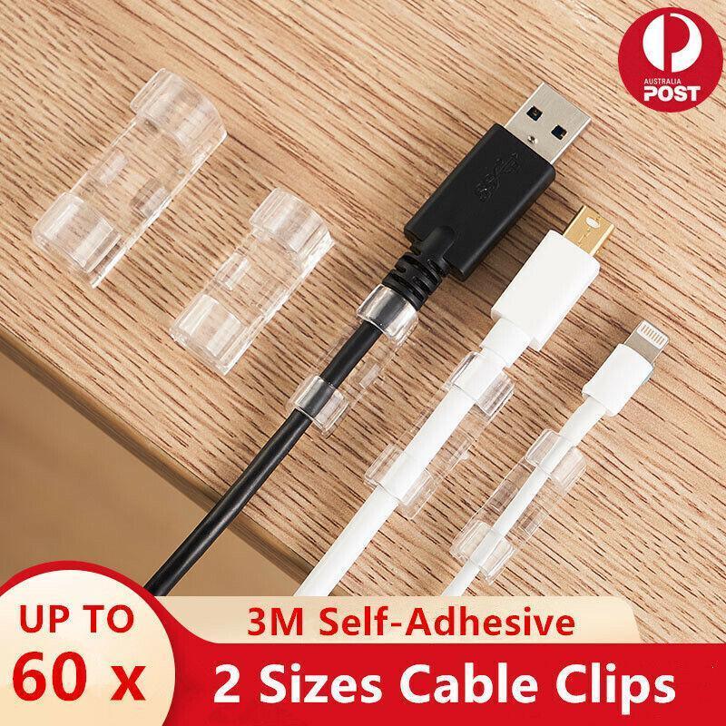 Set of twenty self-adhesive plastic cable management clips organizing power cords on a wooden desk