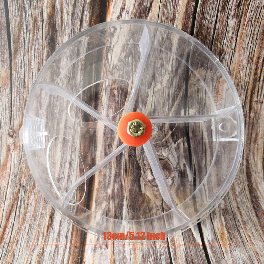 Interactive parrot foraging wheel toy in purple, mounted securely to a bird cage with clear compartments — view 3