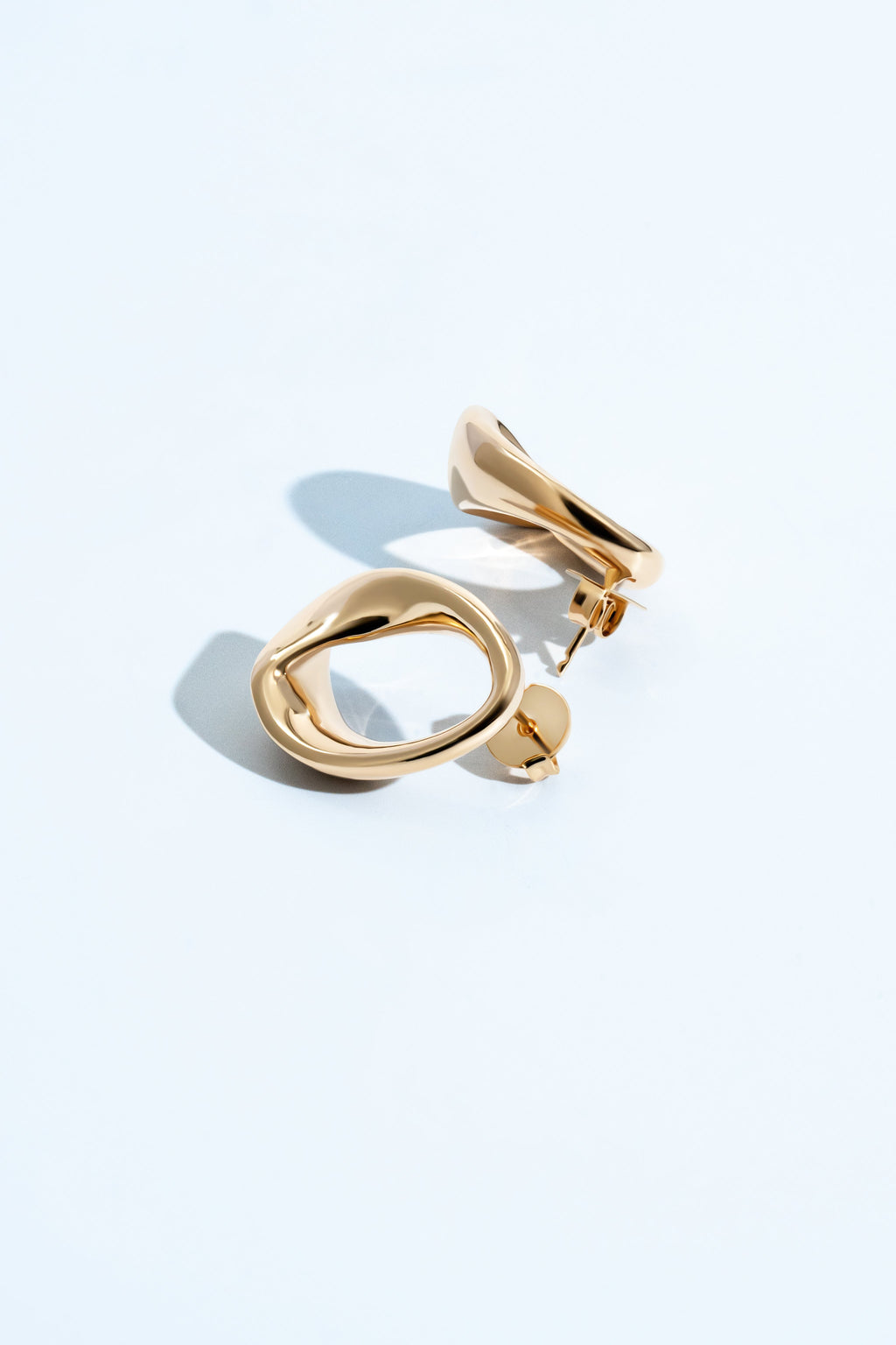 Kate abstract oval drop earrings with a smooth gold finish and fluid geometric sculptural design.