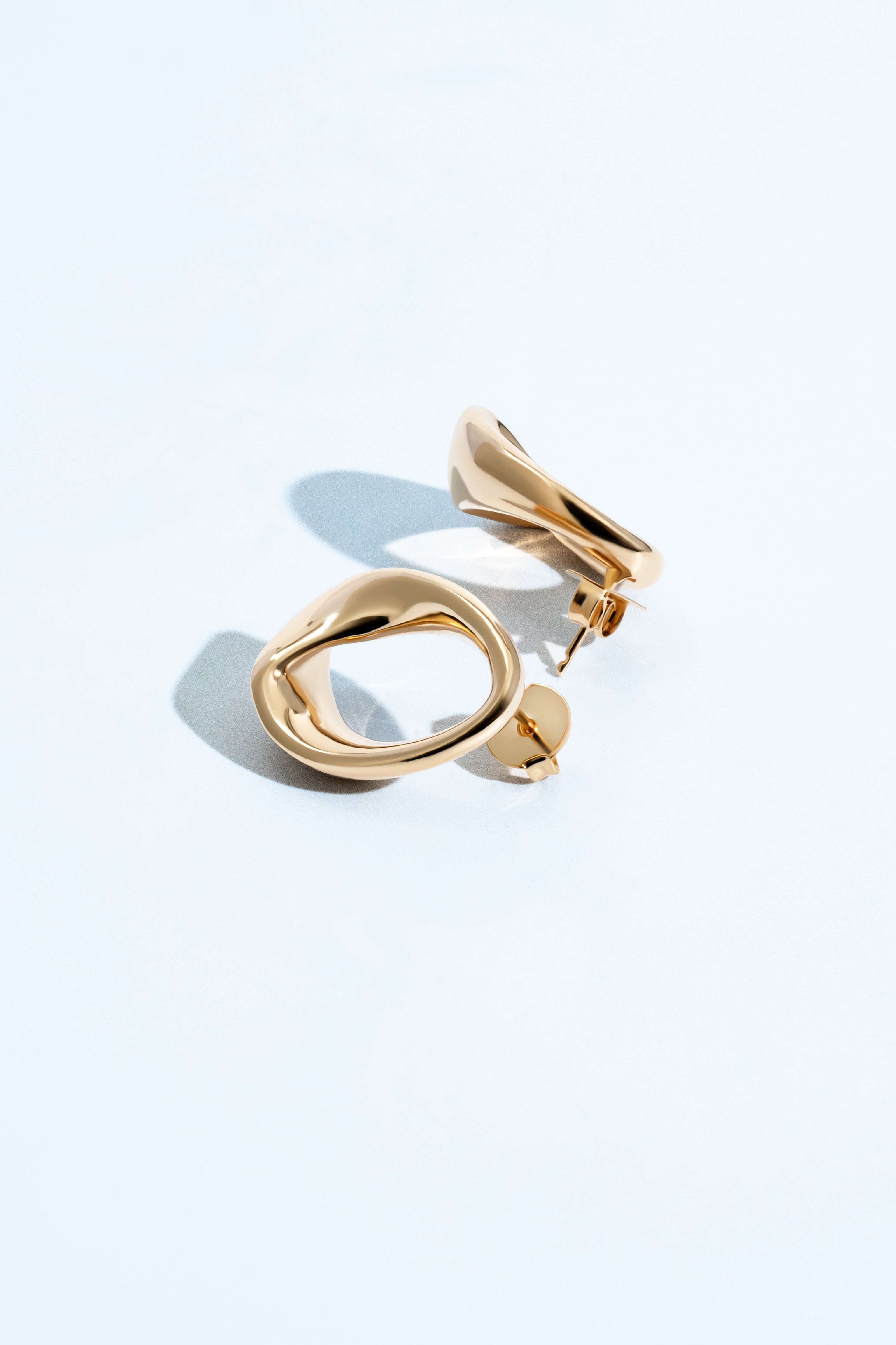 Kate abstract oval drop earrings with a smooth gold finish and fluid geometric sculptural design.