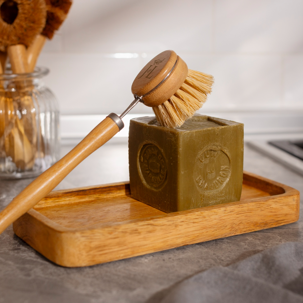 Bamboo long handle dish brush with natural sisal bristles on a kitchen counter