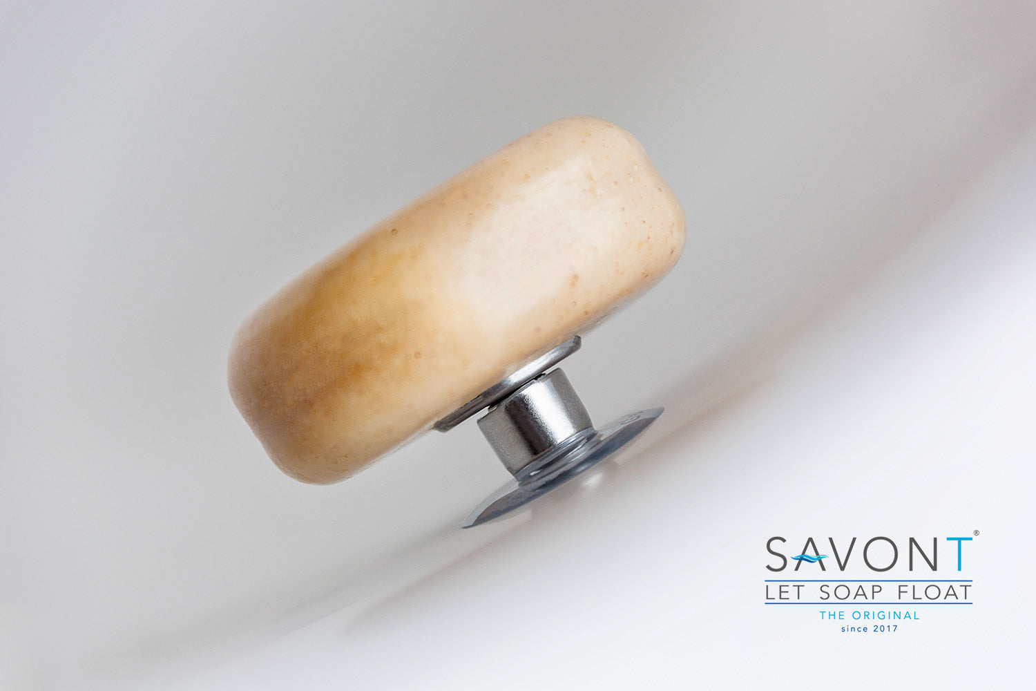 SAVONT magnetic floating soap holder attached to a white bathroom sink with a solid soap bar