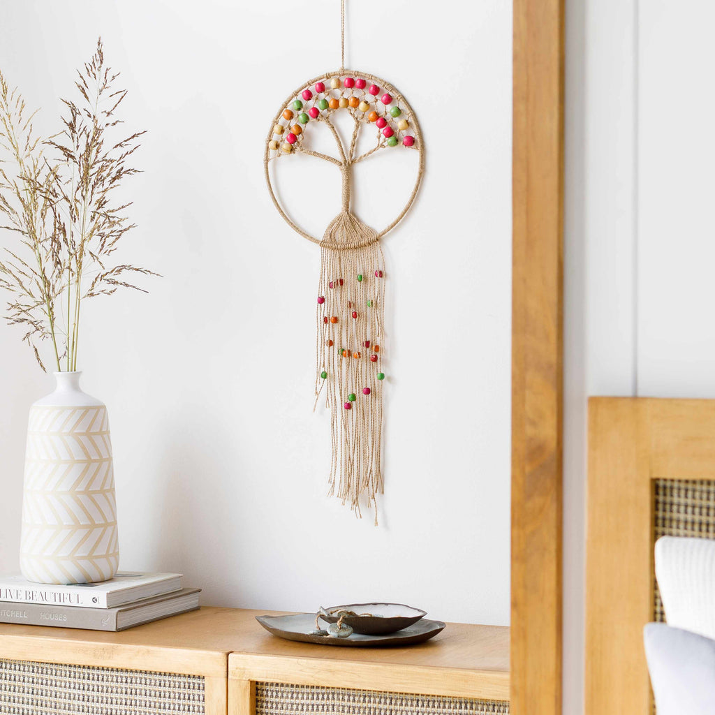Colorful bohemian beaded macrame wall hanging made of natural jute fibers on a wooden rod — view 4