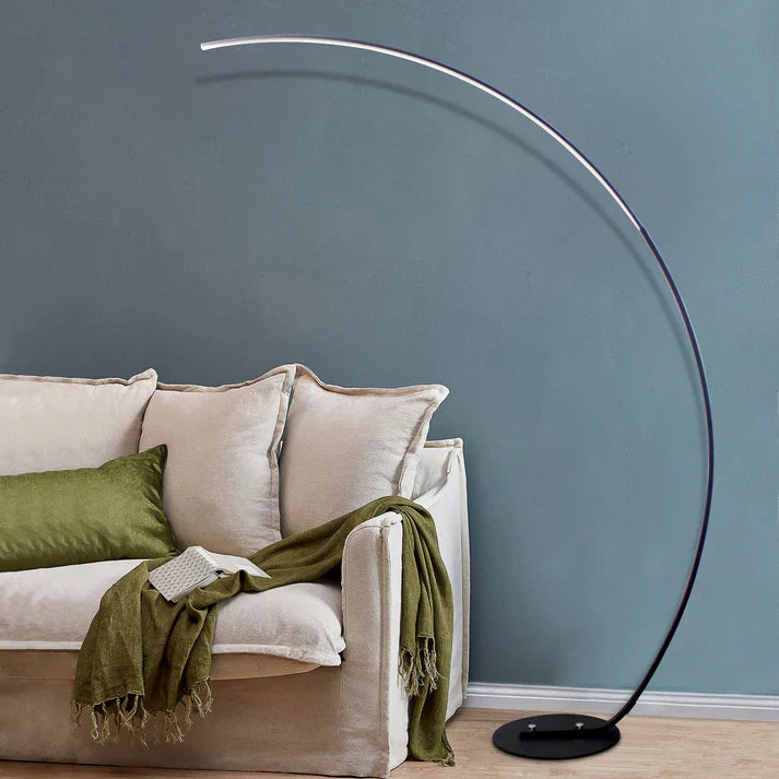 Modern RGBW curved floor lamp in black metal emitting colorful ambient lighting in a room — view 5