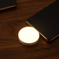Mini portable wireless smartphone light with warm LED illumination plugged into a mobile phone