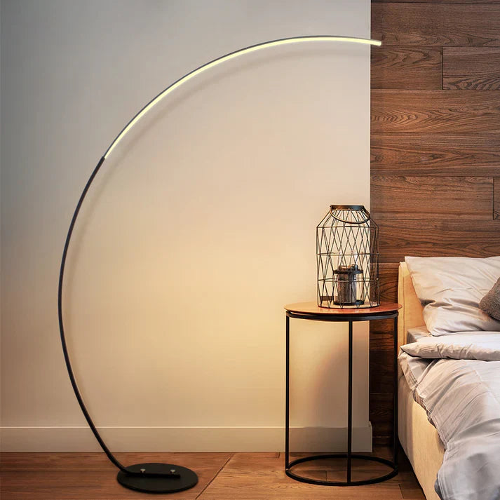 Modern RGBW curved floor lamp in black metal emitting colorful ambient lighting in a room — view 3
