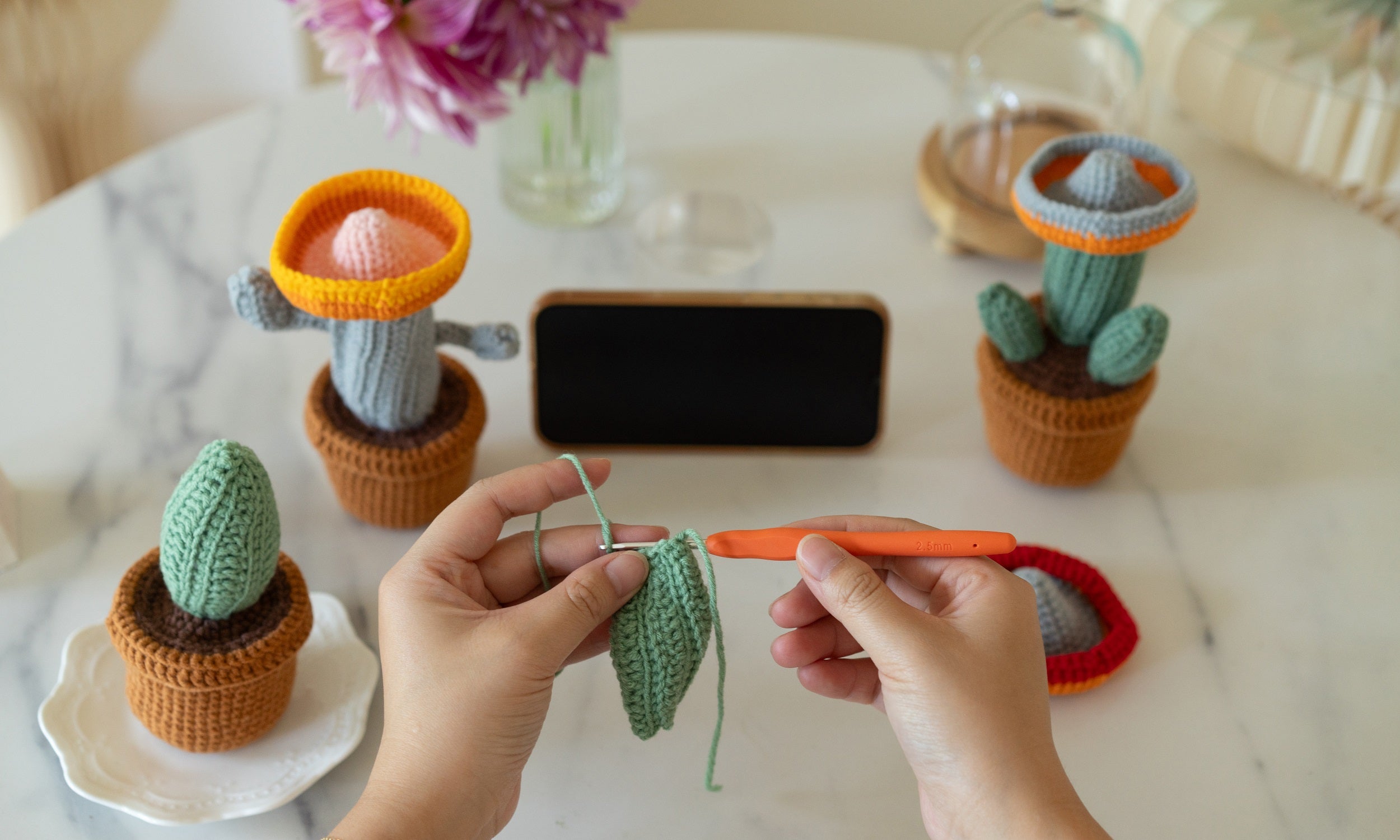 Three handmade amigurumi crochet cacti made from vibrant green yarn and safety eyes — view 4
