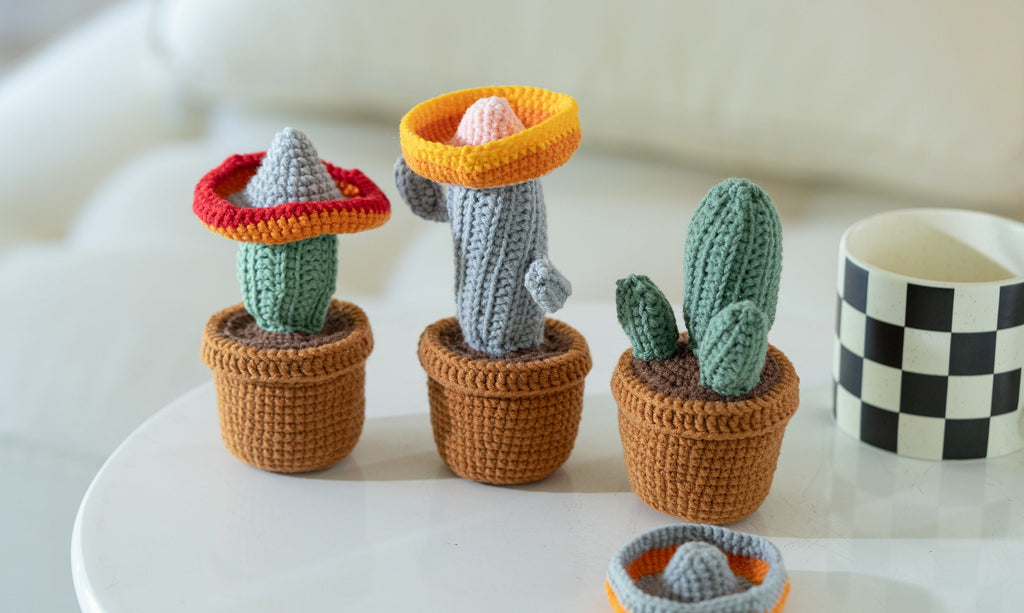 Three handmade amigurumi crochet cacti made from vibrant green yarn and safety eyes — view 2
