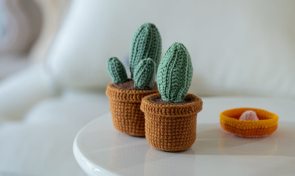 Three handmade amigurumi crochet cacti made from vibrant green yarn and safety eyes — view 3