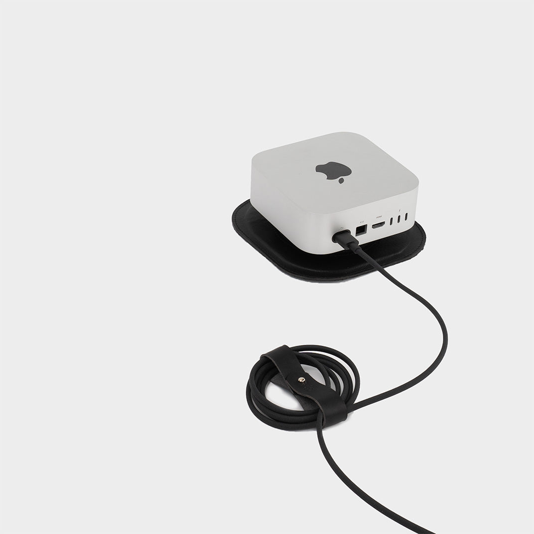 Premium vegetable-tanned leather cord organizer set with metal snap holding a white charging cable — view 4