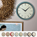 Retro wall clock with a smooth glass face and durable metal casing for vintage home decor