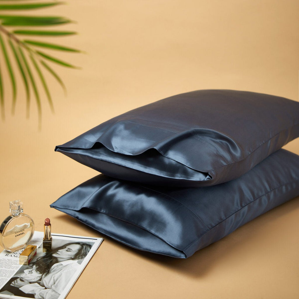 Premium mulberry silk reversible pillowcase duo folded neatly in a soft elegant bedroom setting