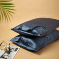 Premium mulberry silk reversible pillowcase duo folded neatly in a soft elegant bedroom setting