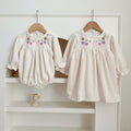 Floral embroidered baby dress in soft white cotton with long sleeves for little girls.