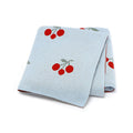 Knitted cherry baby blanket in soft breathable cotton folded neatly for newborn nursery essentials