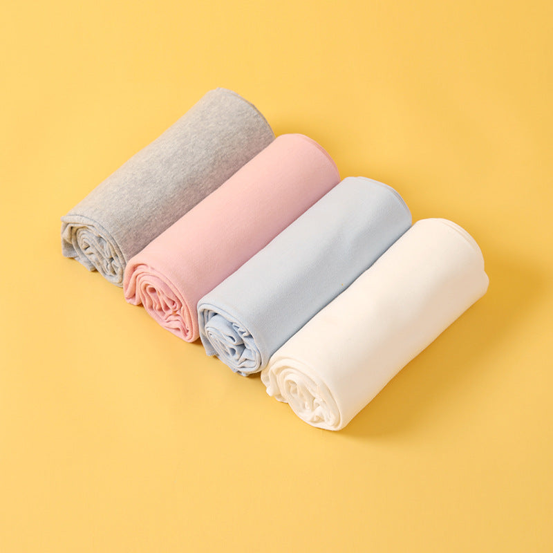 Newborn cotton wrap quilt in solid color, soft baby blanket neatly folded for cozy nursery.